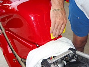 Using a sqeegee to install paint protection film on a Ducati 916