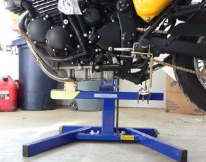 Detail view of underside of motorcycle on Bike-Lift, using engine lifting saddle and Footpeg Mounts.