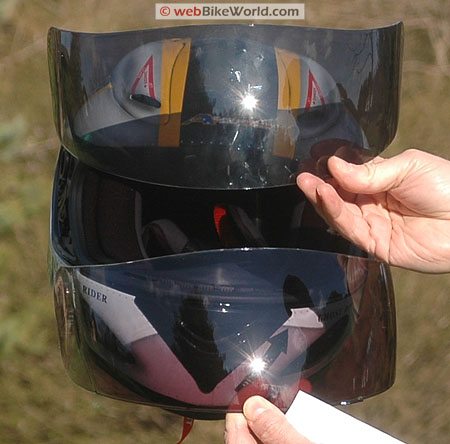 Sunshift Photochromic Motorcycle Helmet Visor at Full Tint (Bottom). Standard Akuma Dark Smoke Tinted Visor (Top).