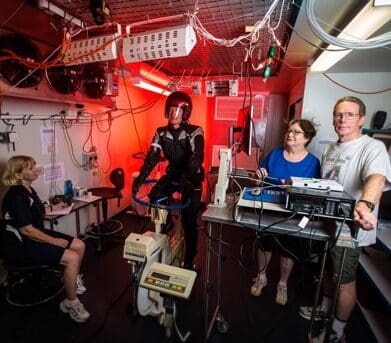 Testing motorcycle in the thermal chamber (from left) research assistant Liz Taylor, volunteer rider Dr Greg Peoples, Liz de Rome and Nigel Taylor. rating award