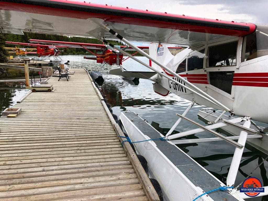 A close up of several float planes tied to a dock.