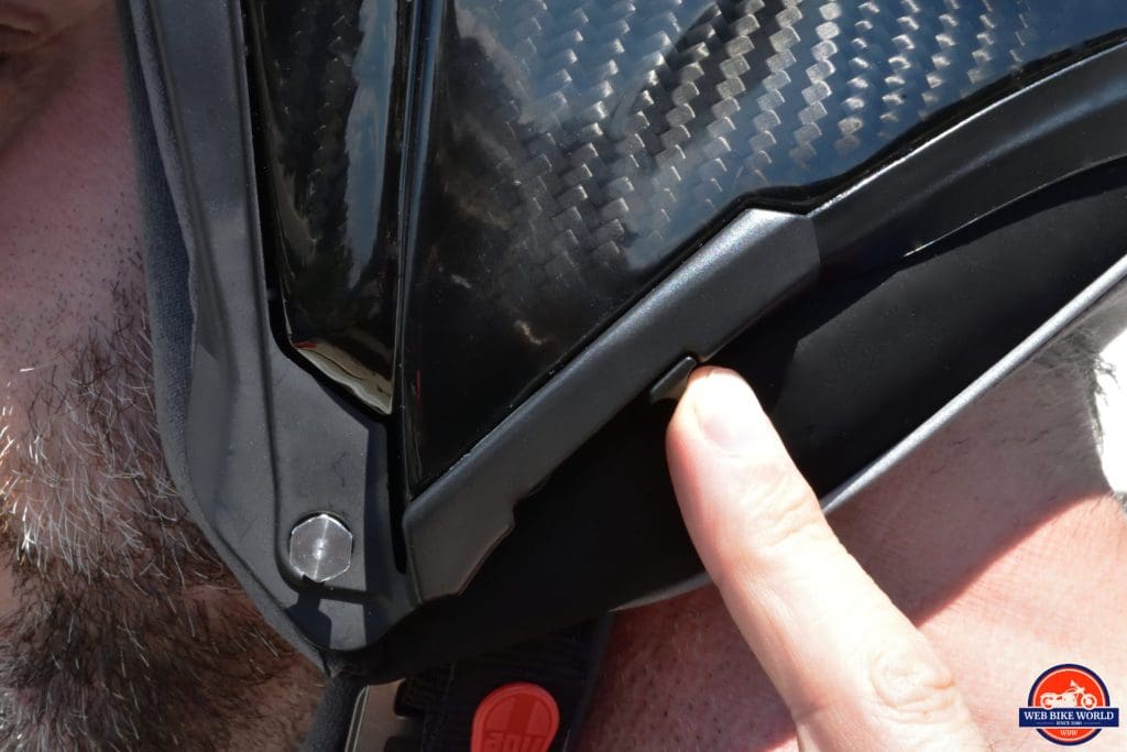 The sliding switch on the helmet for extending or retracting the sun lens.