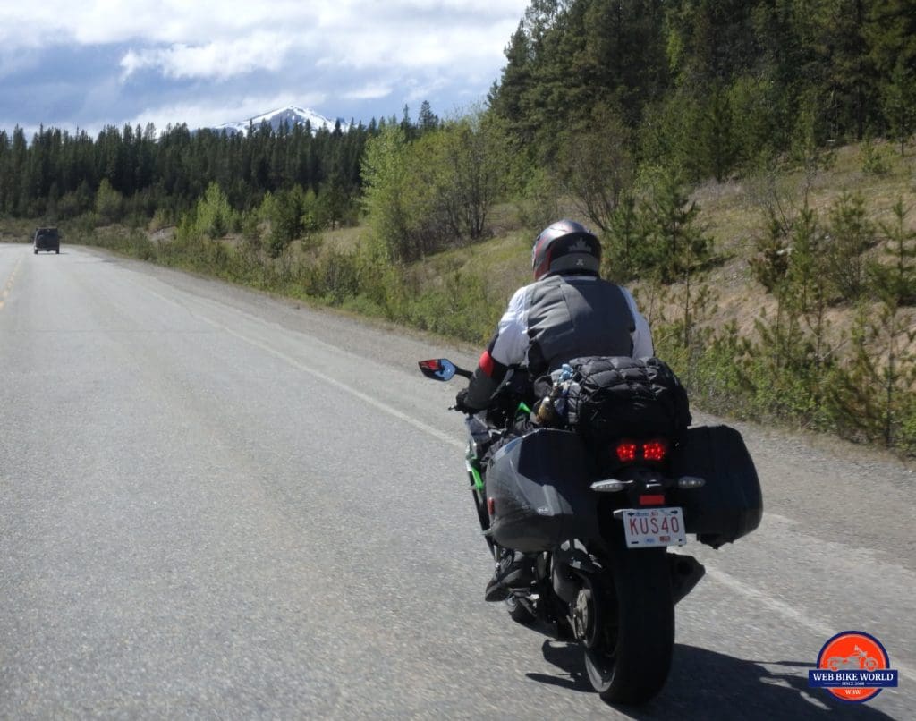 2018 Kawasaki Ninja H2SXSE riding down the road, viewed from behind.