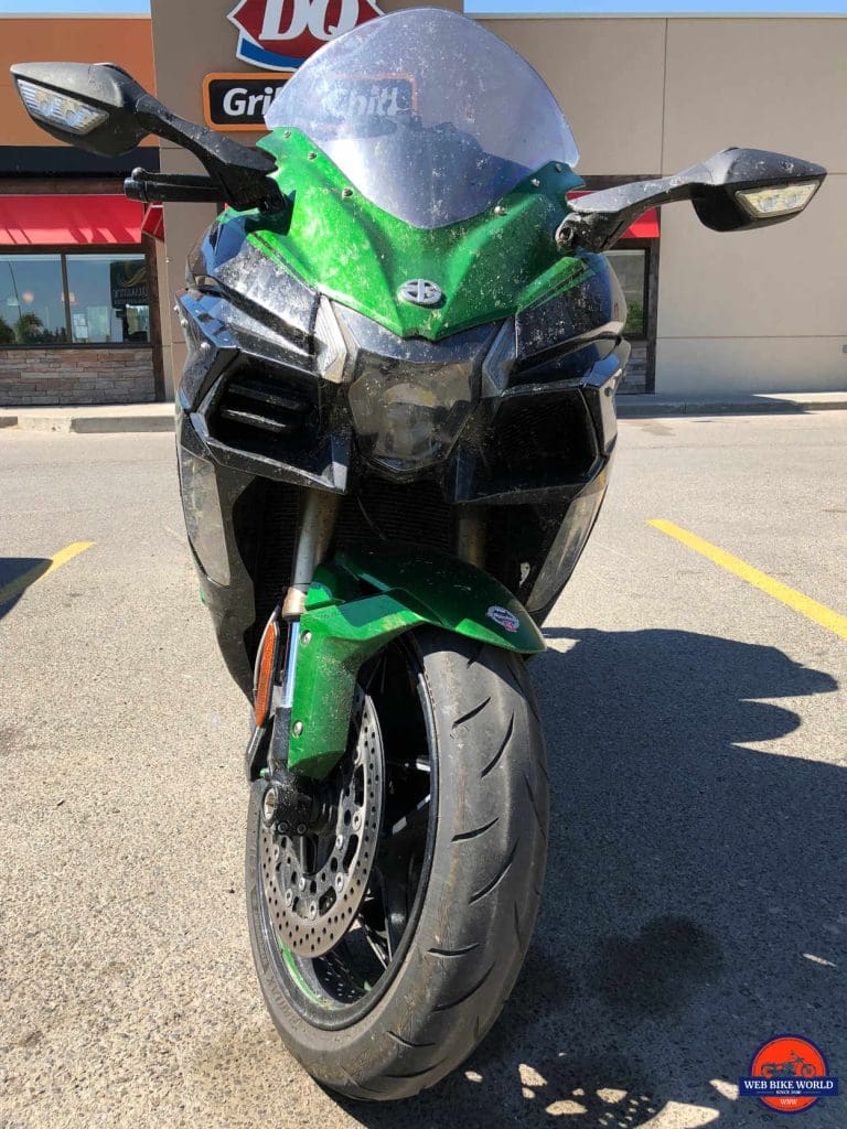 A very dirty 2018 Kawasaki Ninja H2SX SE in a parking lot.