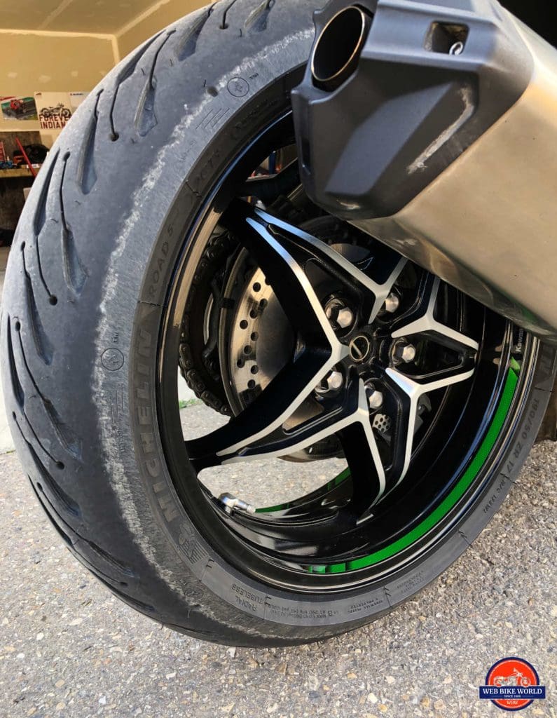 A new Road 5 tire installed on the rear of a Kawasaki H2SX SE.