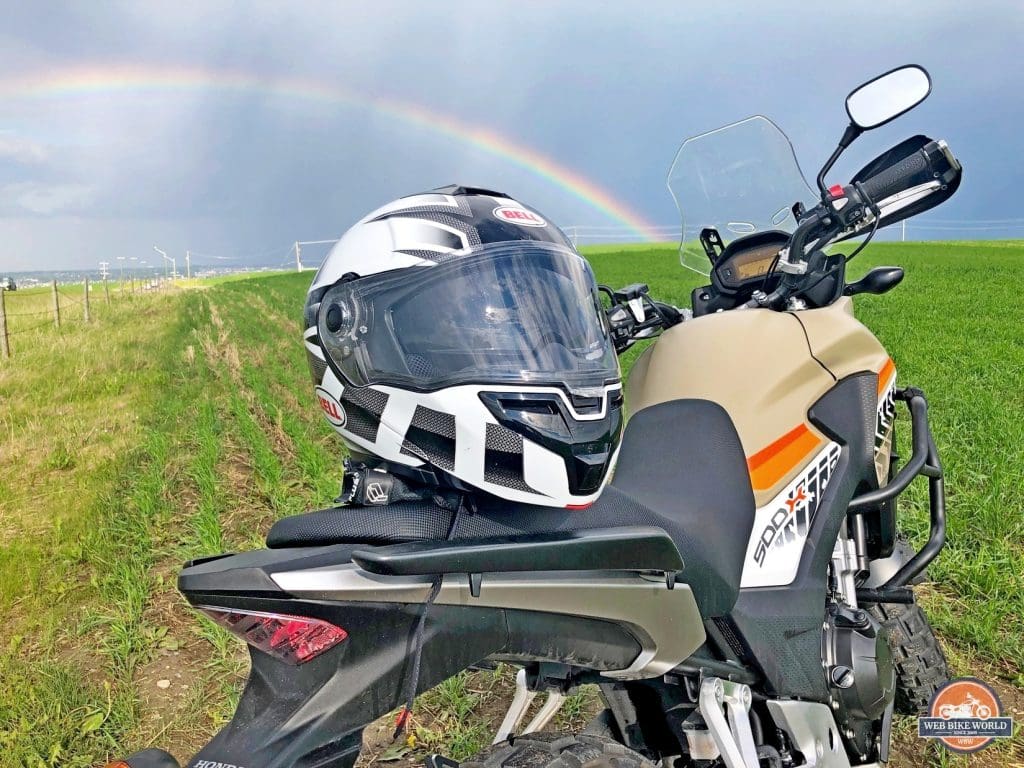 The Bell SRT Modular on a CB500X with a rainbow in the background.