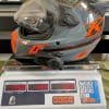 The Klim Krios Pro with a Sena 10 EVO installed on it being weighed.
