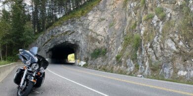 A Harley Davidson parked in front of a tunnel.