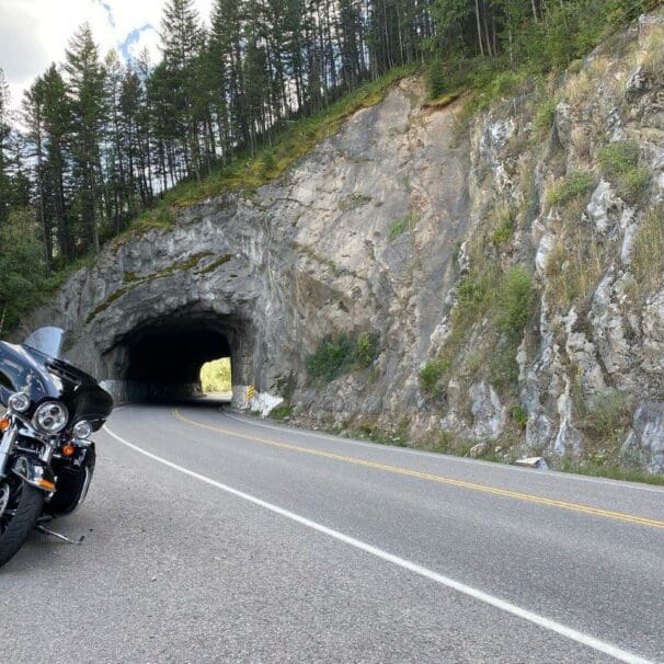 A Harley Davidson parked in front of a tunnel.