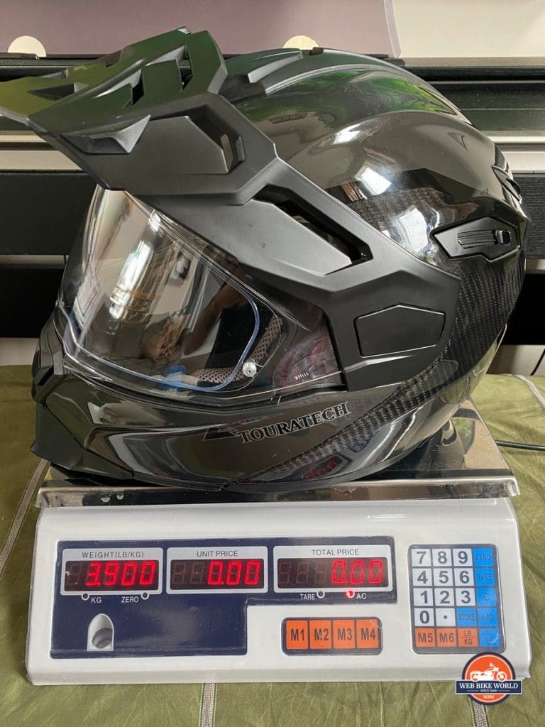 The Touratech Aventuro Traveller Carbon helmet on a scale (in pounds).