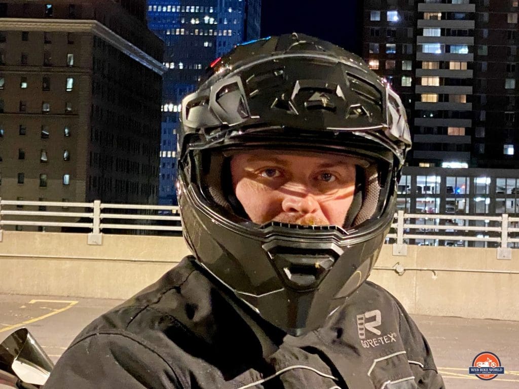 Rider wearing the Touratech Aventuro Traveller Carbon with visor up.