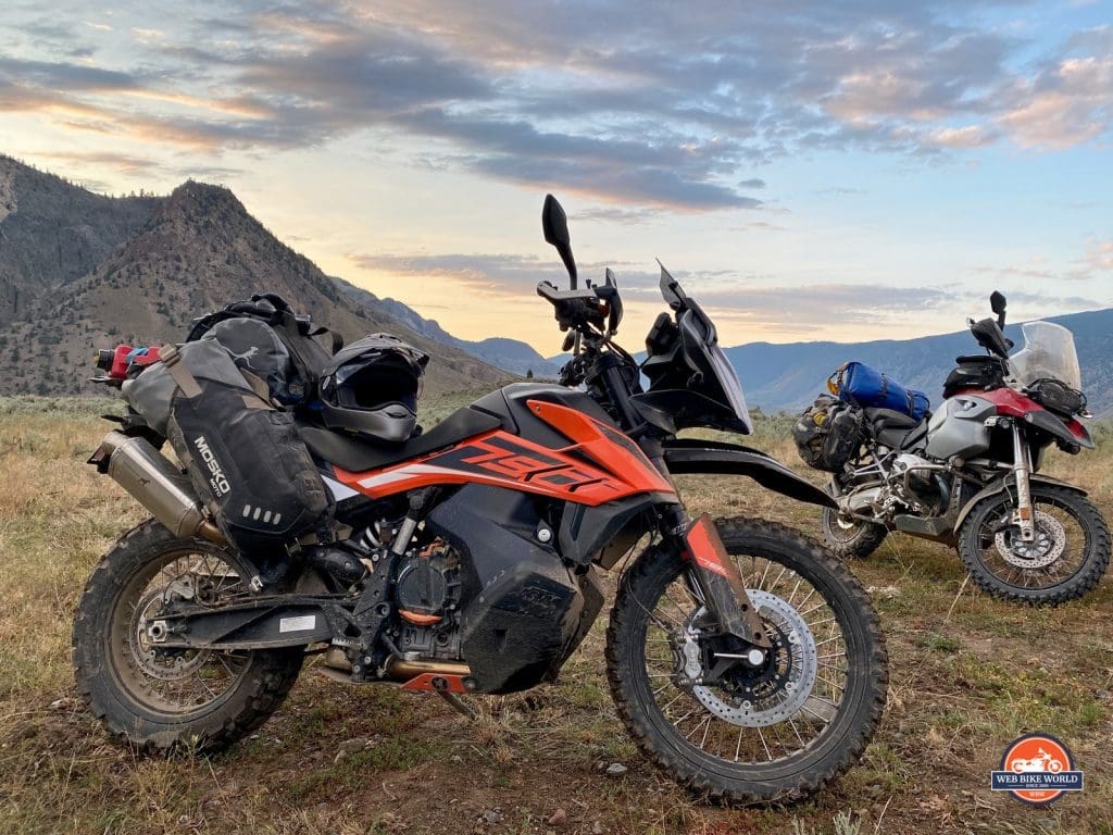 A KTM 790 Adventure and BMW R1200GS parked in front of a sunset in British Columbia, Canada.