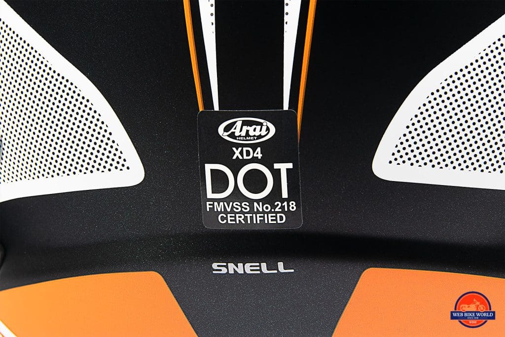 The Snell and DOT stickers on the back of the Arai XD-4 helmet.