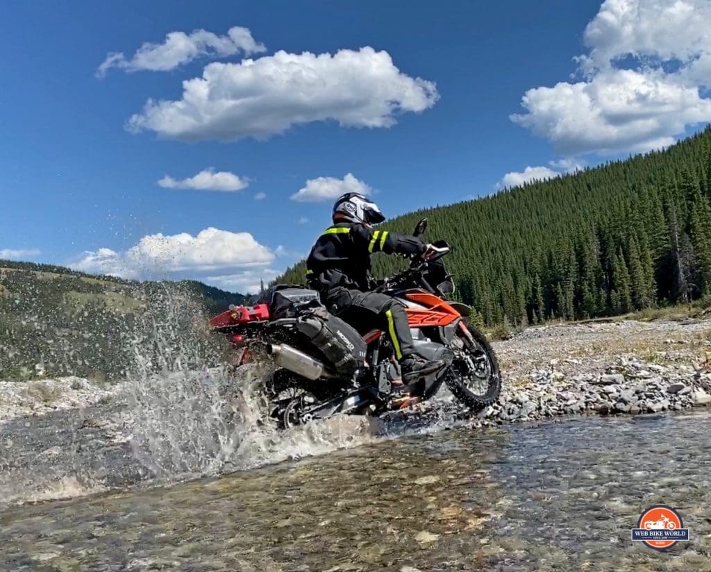 Jim Pruner riding his KTM 790 Adventure through water while wearing the Arai XD-4 helmet.