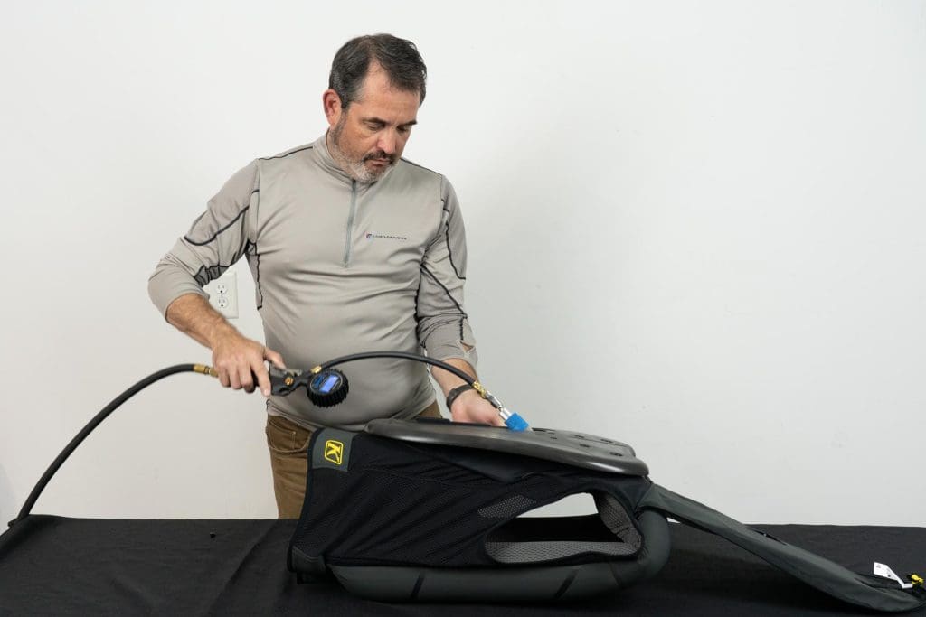 Individual inflating the Klim Ai-1 Airbag Vest with air pump.