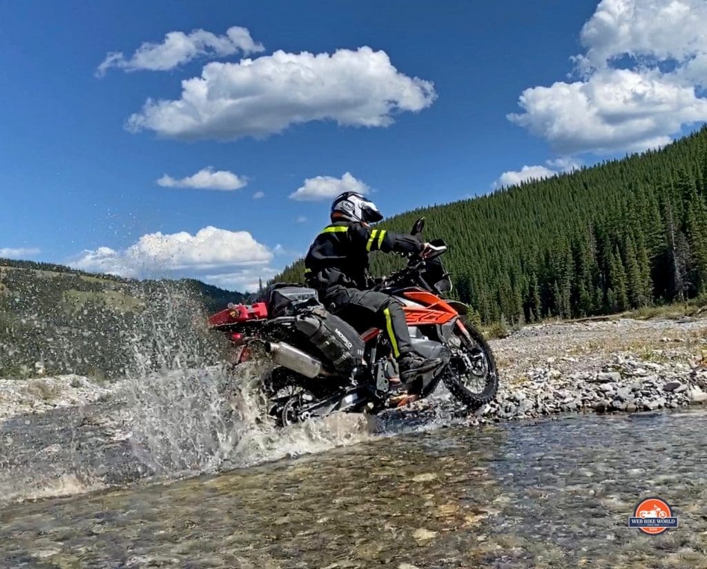 Jim Pruner riding through a stream while wearing the Joe Rocket Canada Whistler Adventure boots.