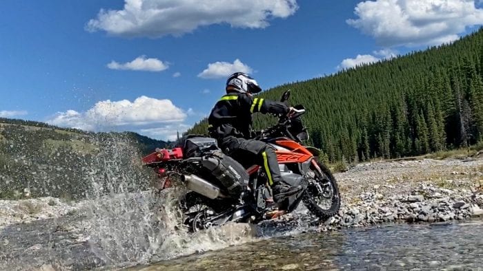 Jim Pruner riding through a stream while wearing the Joe Rocket Canada Whistler Adventure boots.