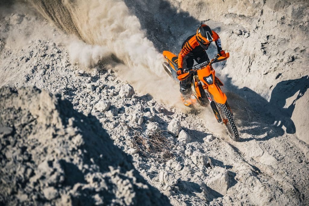 Rider climbing a soft sandy dirt hill on KTM 350 EXC-F