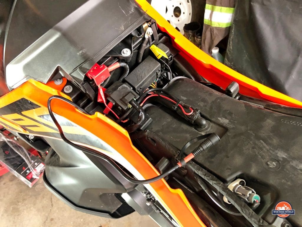 The 12V battery harness connected to the battery terminals on a KTM 790 Adventure.