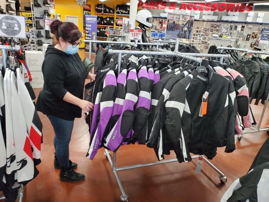 Female shopping for motorcycle jackets