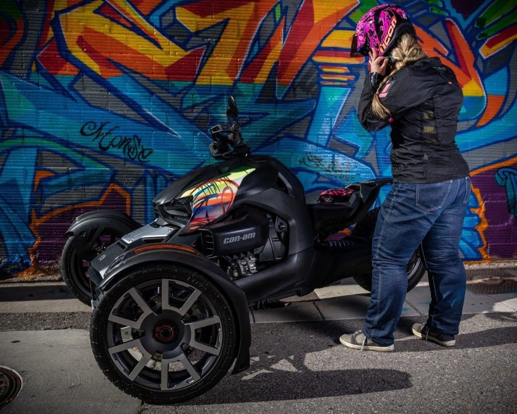 Rider Brittany Morrow putting on her motorcycle helmet