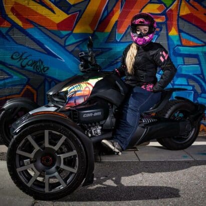 Writer Brittany Morrow on the Can-Am Ryker 900 Rally Edition in front of graffiti wall.