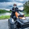 Rider on Can-Am Ryker 900 Rally Edition with lake behind her.