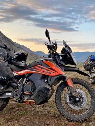 The Mosko Moto Reckless 80L V3.0 on a KTM 790 Adventure with a BMW R1200GS in the background.