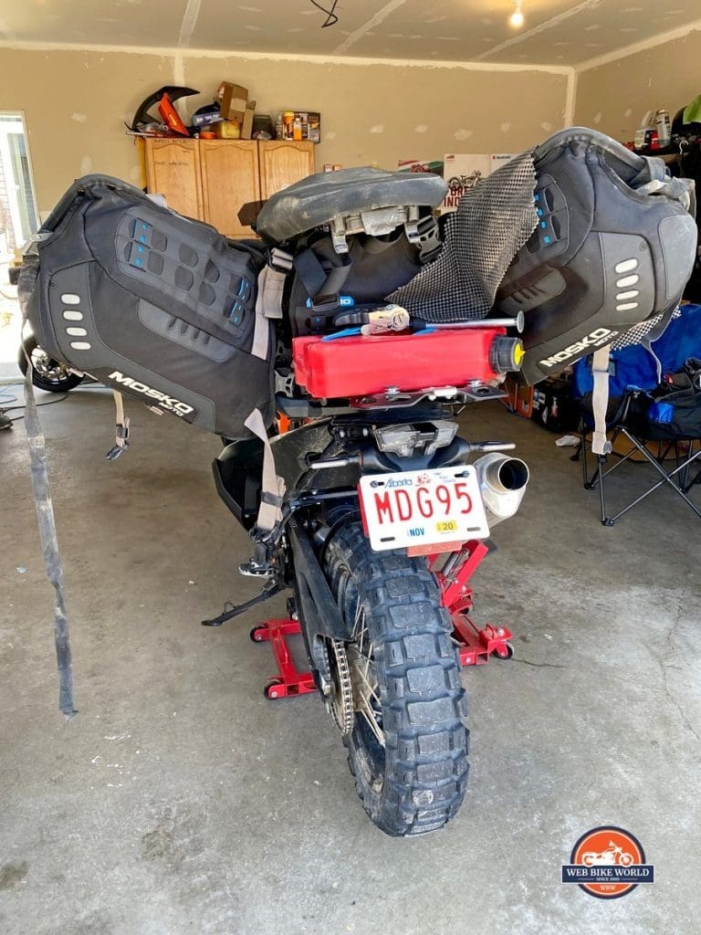 The Mosko Moto Reckless 80L V3.0 Revolver half removed from a KTM 790 adventure to access under the seat.