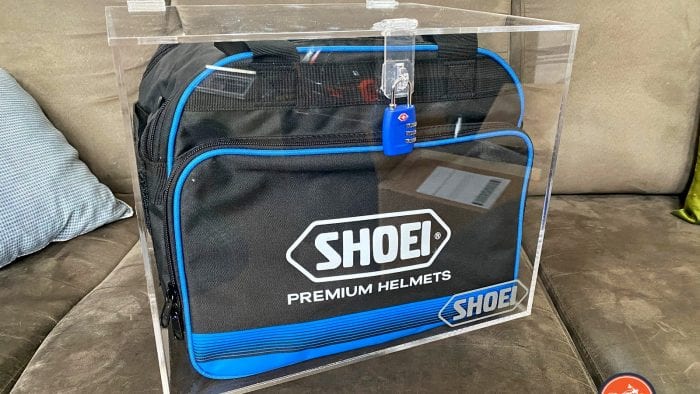 Mystery Shoei helment encased in a locked plexiglass box. Mystery Shoei helment encased in a locked plexiglass box.
