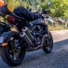Indian FTR 1200 S with Touring Accessory package parked on a gravel road with old pickup trucks in Montana