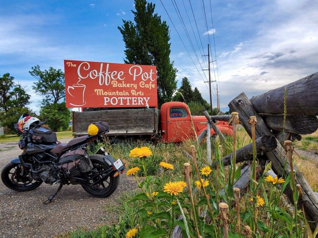 Indian FTR 1200 S parked at a coffee shop with an old pickup truck in Montana
