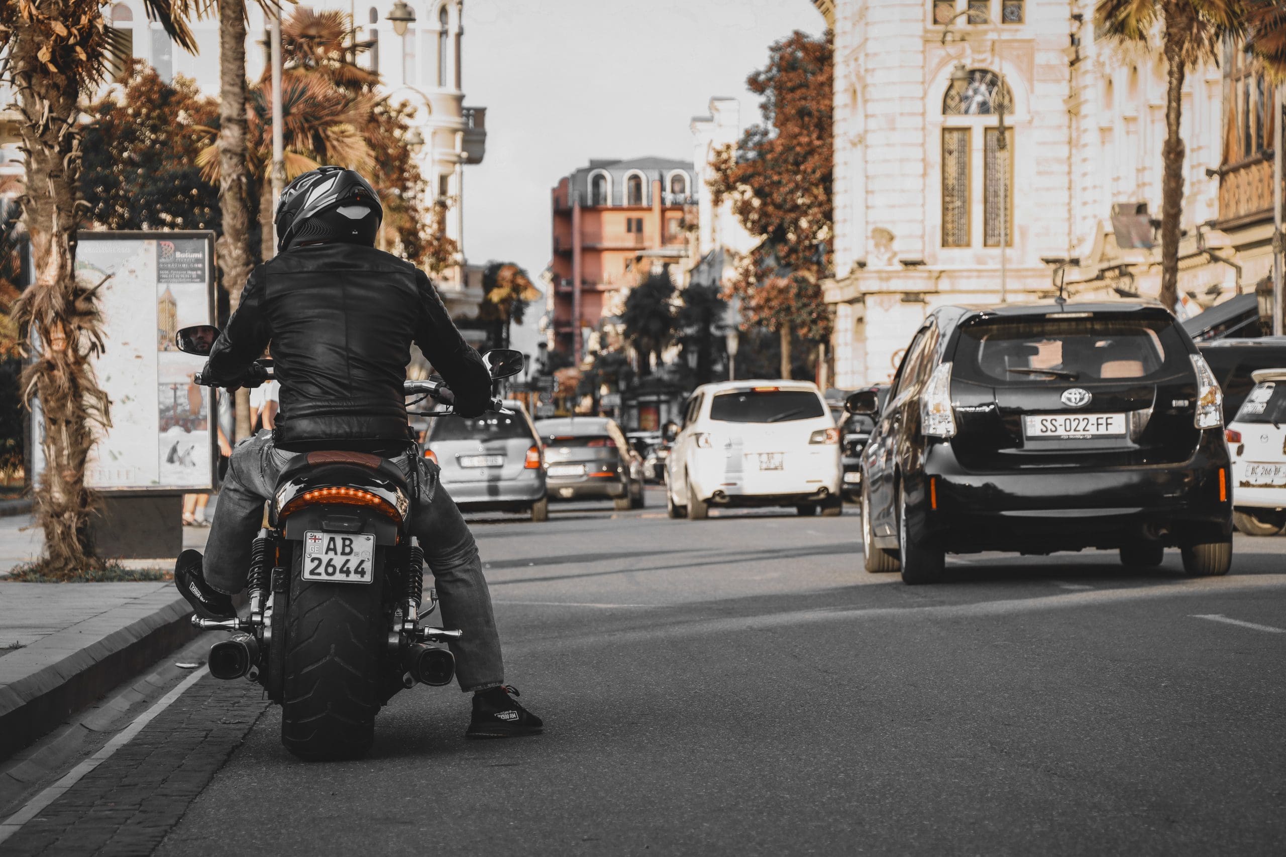 man riding motorcycle on side of road