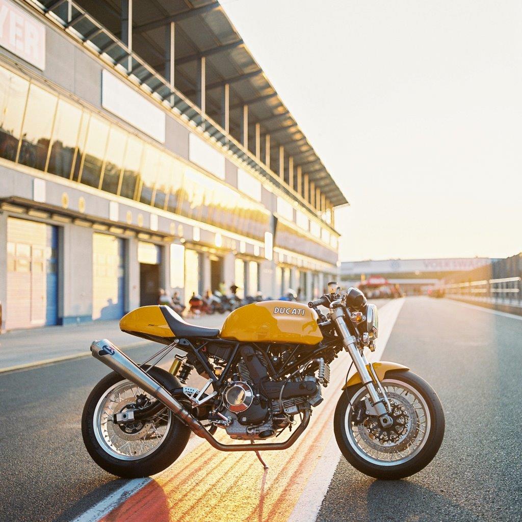 Ducati Sport Classic motorcycle at a race track at sunset