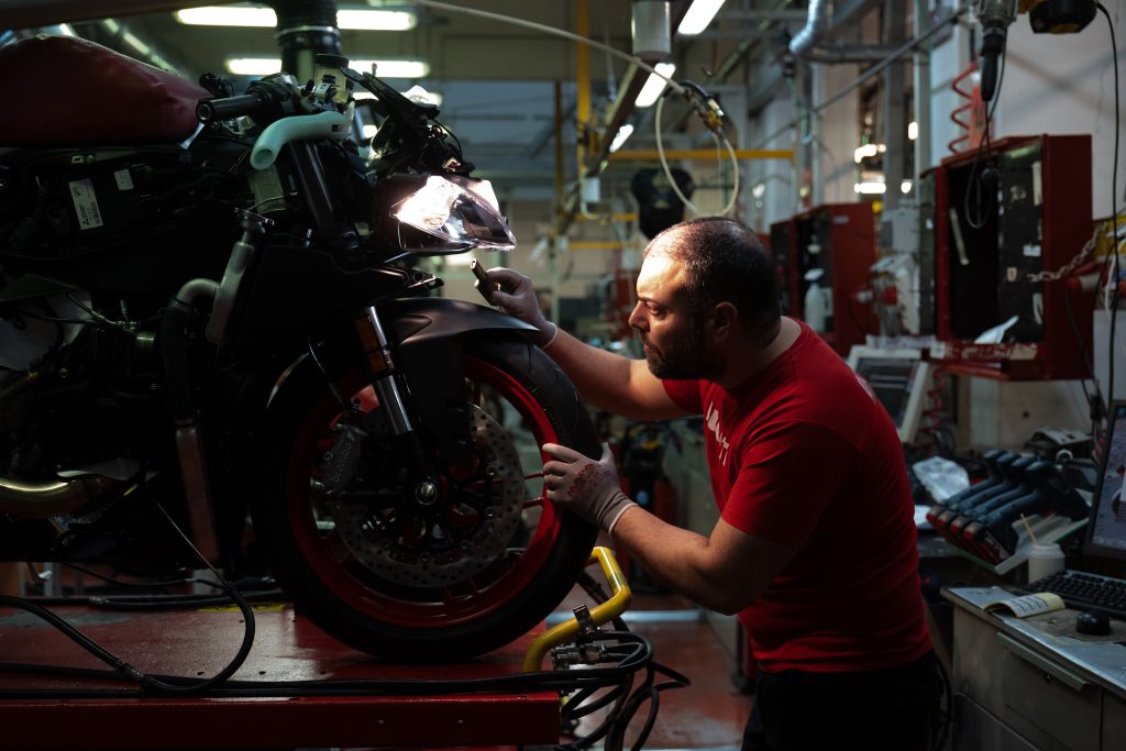 Mechanic inspecting front motorcycle wheel
