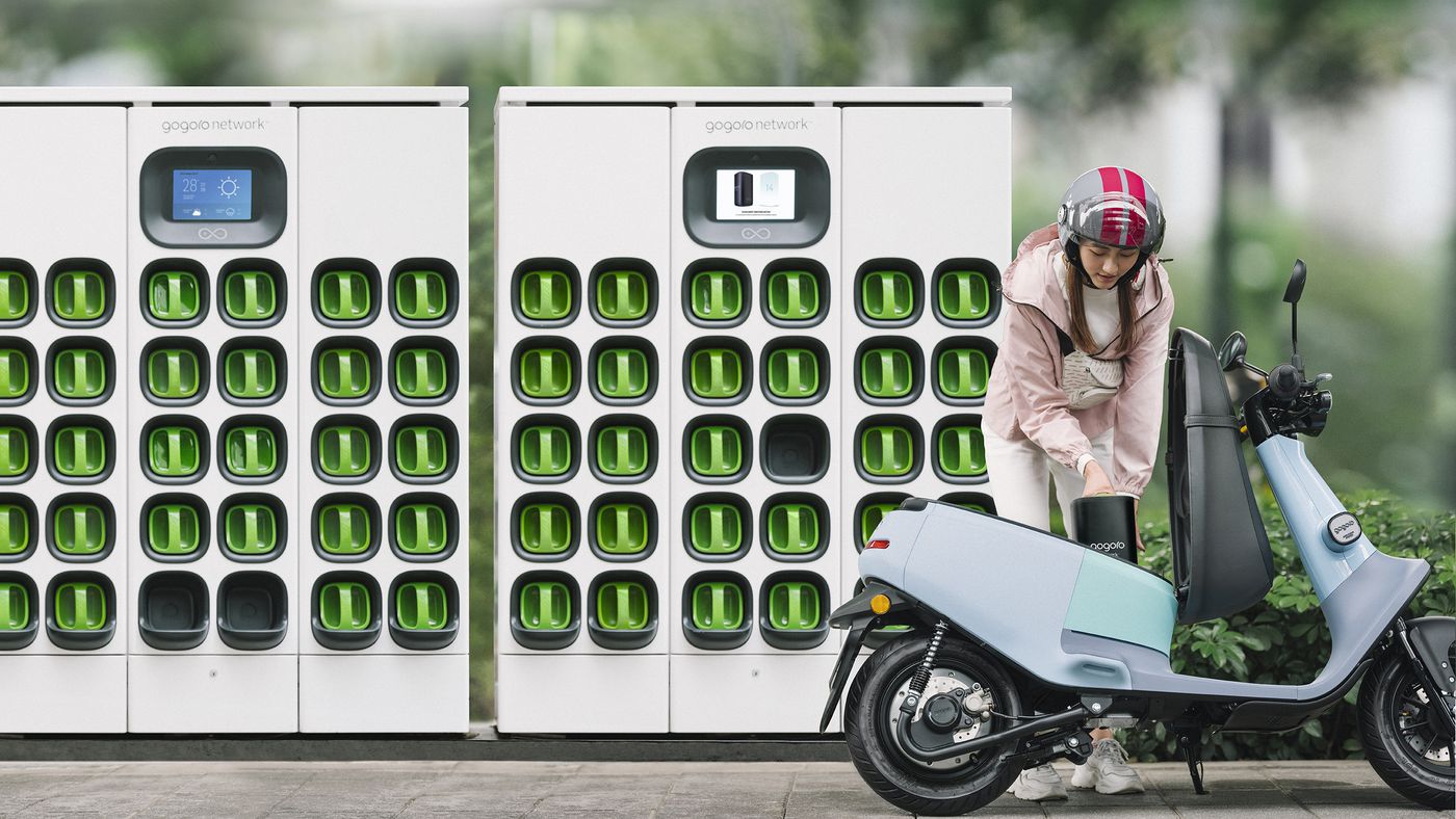 Girl swapping batteries out of an electric scooter at Gogoro battery-swapping platform