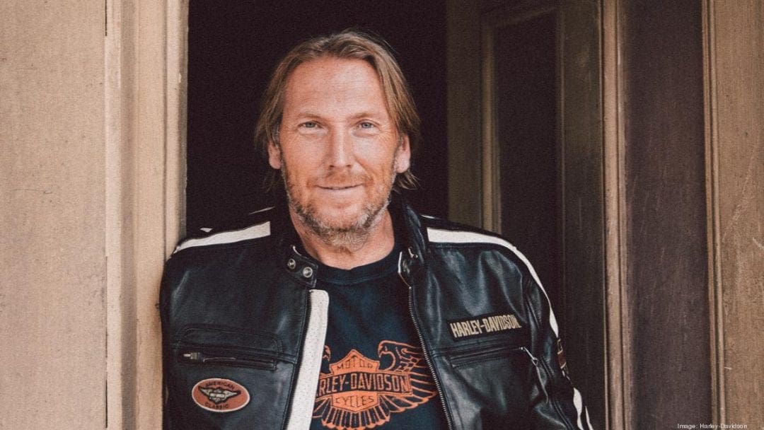 Jochen Zeitz, President of Harley Davidson, posing with a company leather jacket.