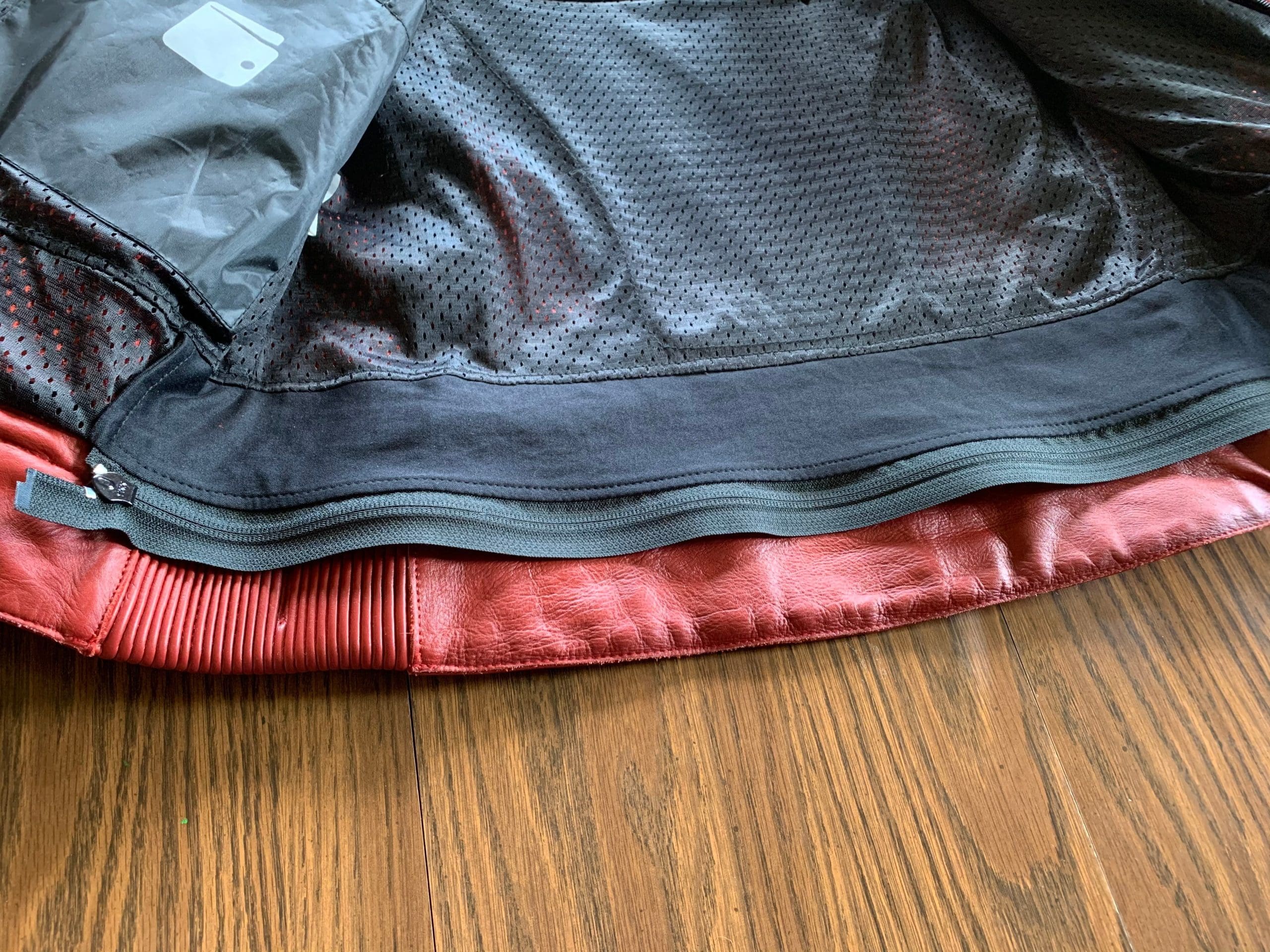 Bottom zipper for attaching jacket to riding pants