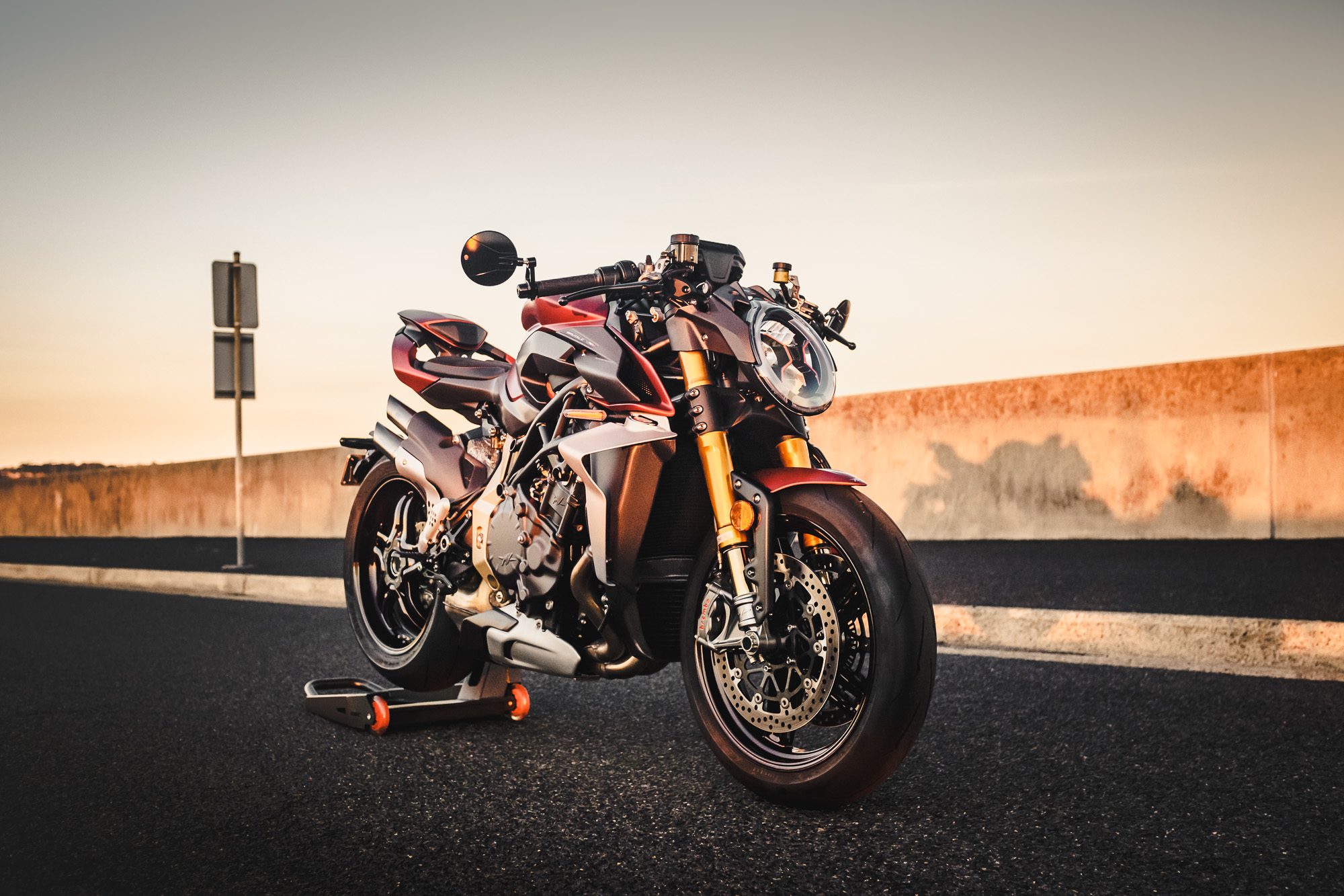 A MV Agusta Brutale motorcycle on an industrial road at sunset