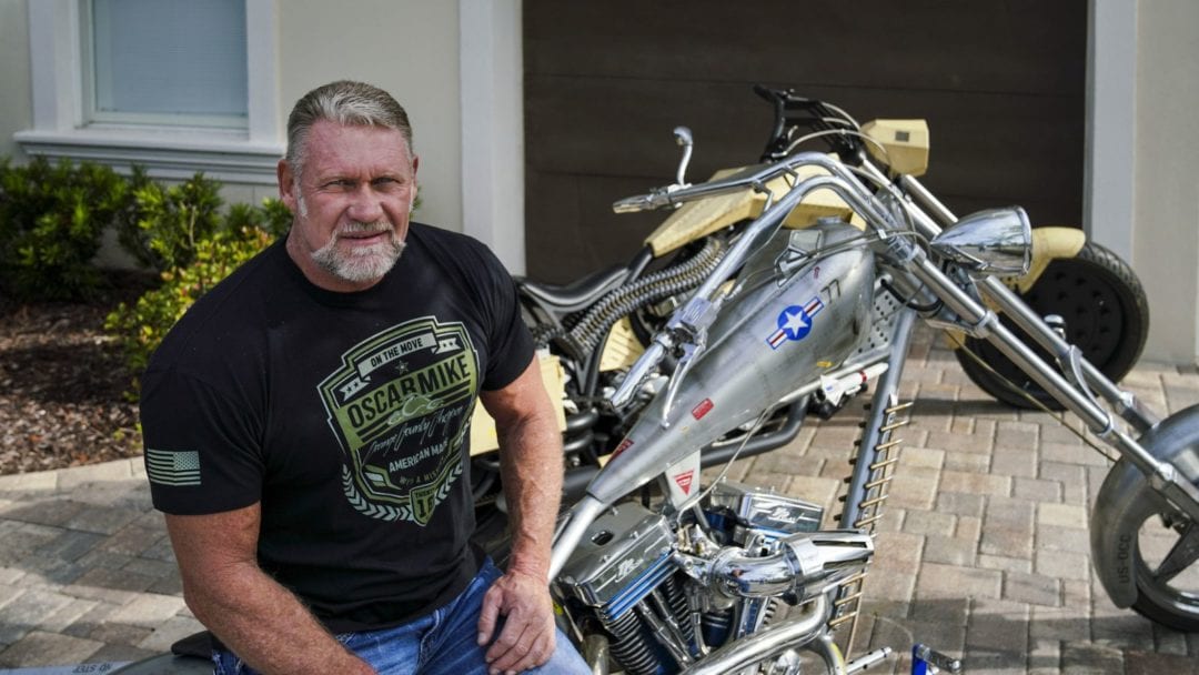 Paul Tetul Sr., next to his shiny chrome-y motorcycle