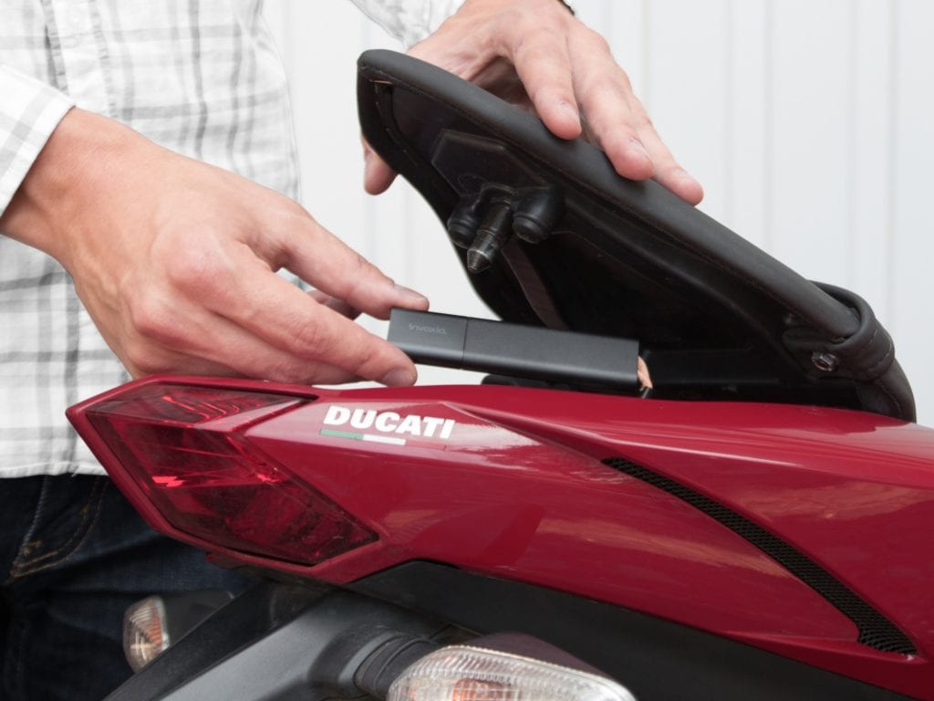 Putting the tracker in the tail storage area of Ducati/ stock photo