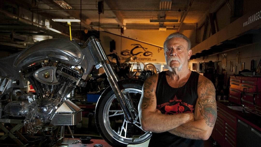 Paul Tetul Sr., next to a chopper build in a shop