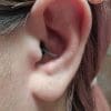 A close-up of a woman wearing MOTO PRO ear plugs.