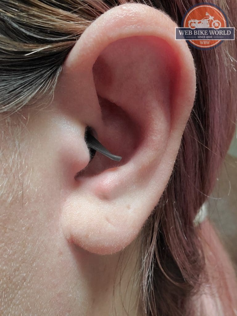 A close-up of a woman wearing MOTO PRO ear plugs.