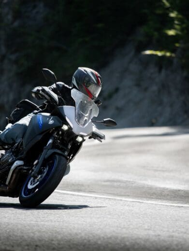 Motorcycle rider taking the twisties at speed. Photo by Jakub Sisulak