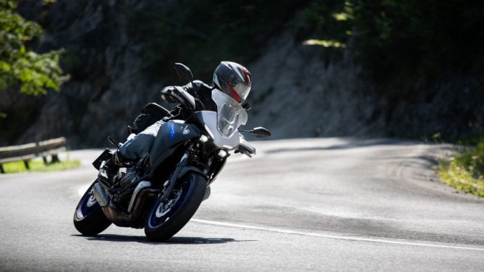 Motorcycle rider taking the twisties at speed. Photo by Jakub Sisulak