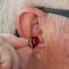 A man inserting a hearing aid