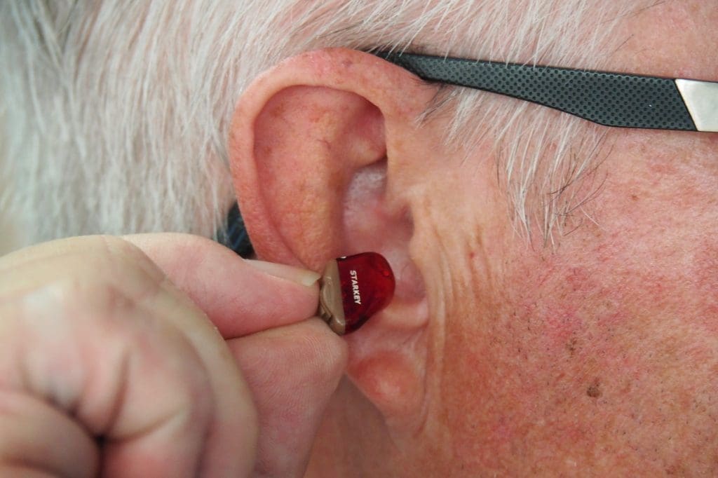 A man inserting a hearing aid