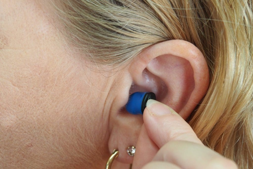 A woman inserting an earplug