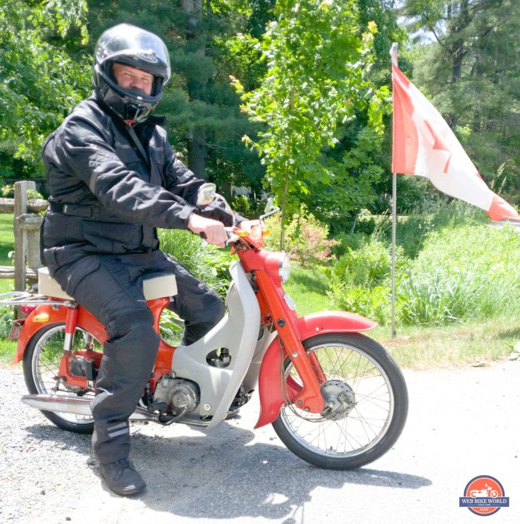 A side profile of a rider trying out the Gryphon Moto Indy Pants, riding a motorcycle